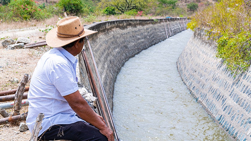 A farmer overlooks an irrigation canal in Piura, Peru