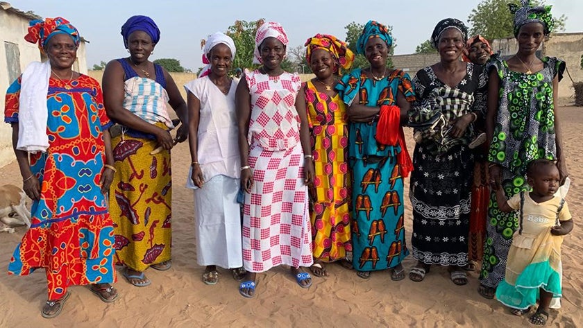 Senegalese women in colorful dresses stand for group photo