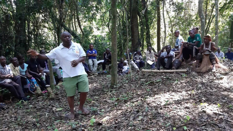 Man speaking to an audience in the forest