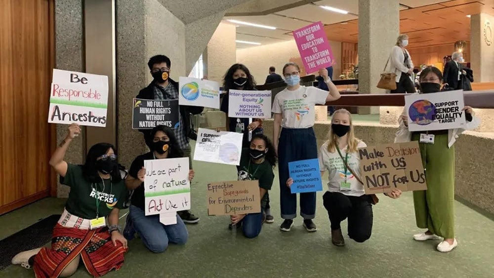 Young people holding protest signs at a conference