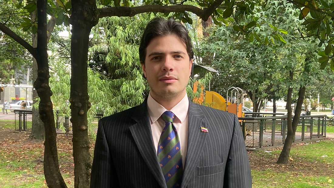 Man in suit and tie standing in a park
