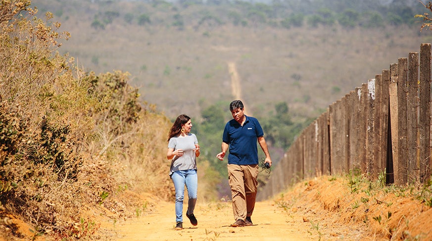 Clara Fonseca walking with a man on a dirt path