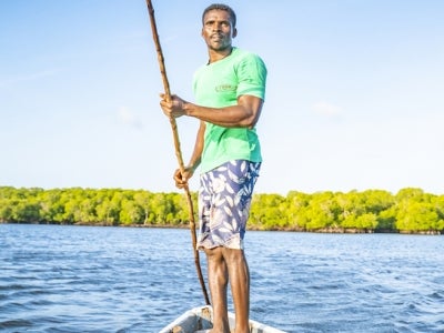 Man standing on a small boat in Kenya