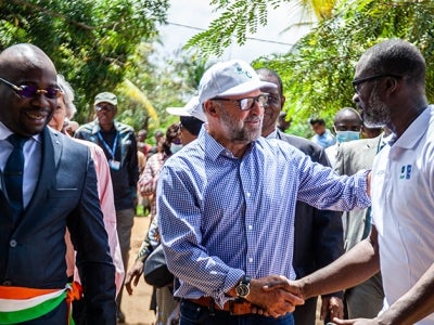 Carlos Manuel Rodriguez, CEO and Chairperson of the GEF, shaking hands with people in Marchoux village, Cote d'Ivoire