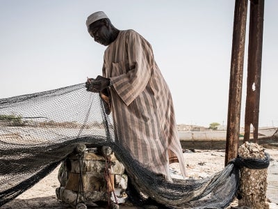 Senegalese man fixing a fishing net