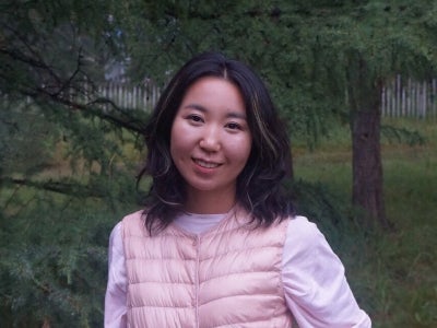 Portrait of a girl in pink vest in a forested area