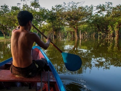 Boy on boat with paddle through Indigenous territory and protected area on the Tapajós River, Amazon - Brazil