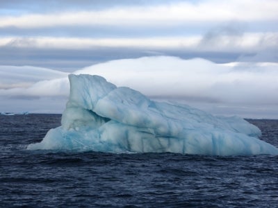 Tilted iceberg in open ocean.