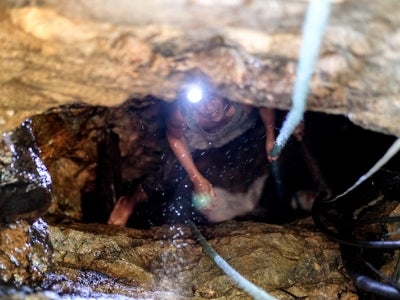 Small-scale gold miner inside a mining site looking up at camera