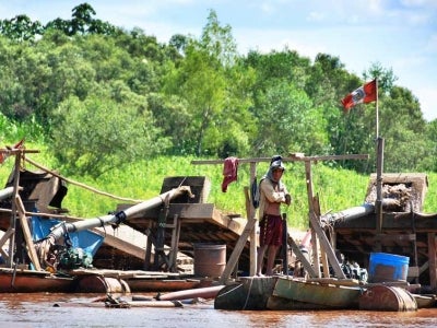 Illegal gold mining operation on small jungle river in Peru