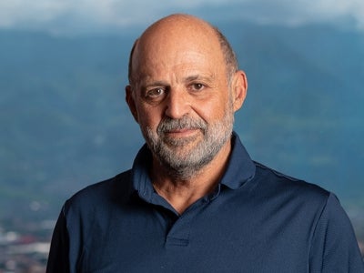 Carlos Manuel Rodriguez head shot with mountain background