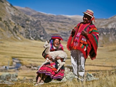 Peruvian women in traditional dress with alpaca