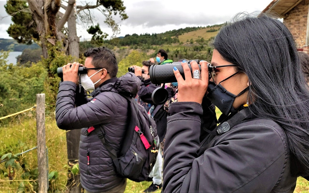 Members of the Lake Tota Basin Phenological Bird Monitoring Network observe a plains monkey (Quiscalus lugubris) in the Pueblito Antiguo Nature Reserve