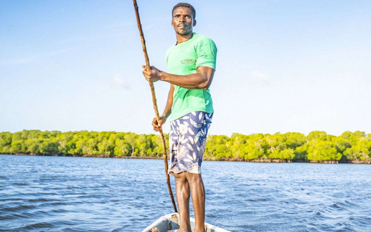 Man standing on a small boat in Kenya