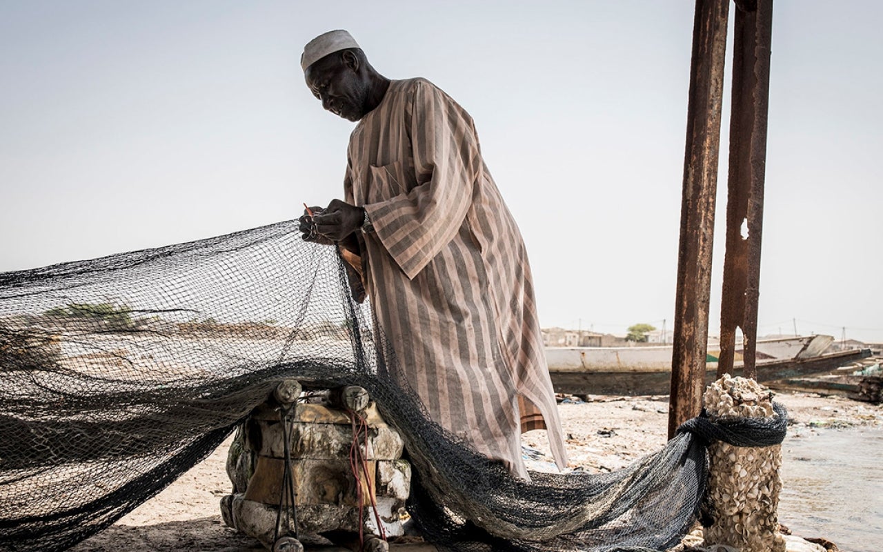 Senegalese man fixing a fishing net