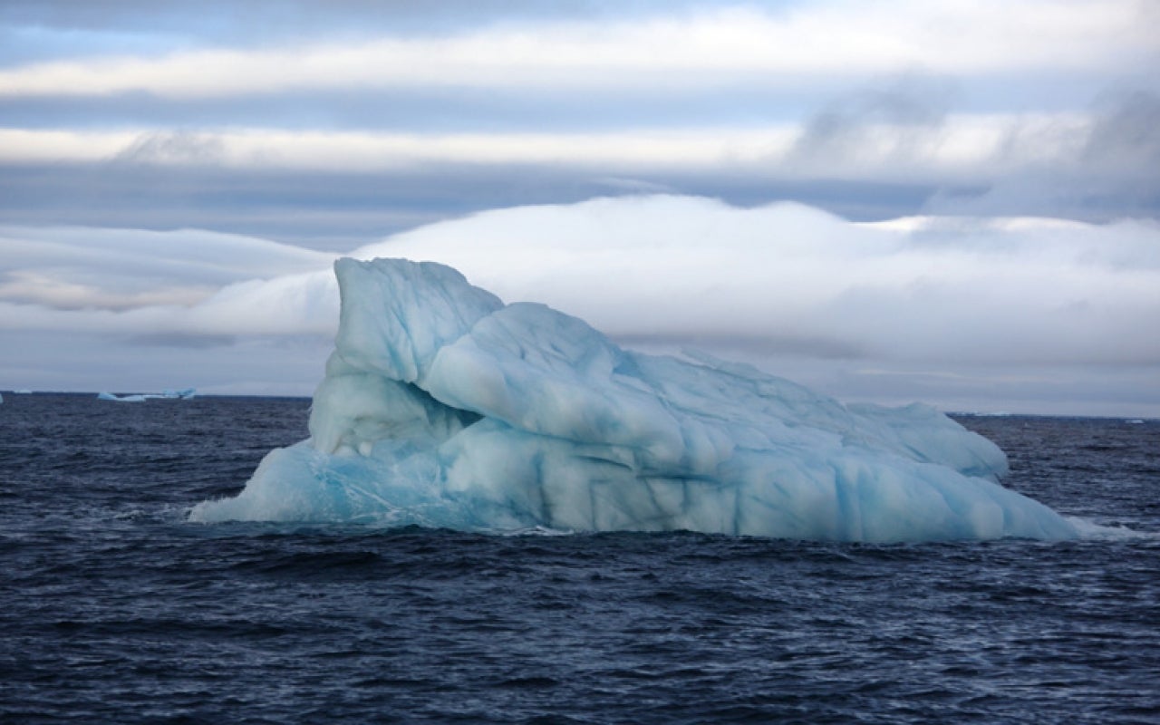 Tilted iceberg in open ocean.