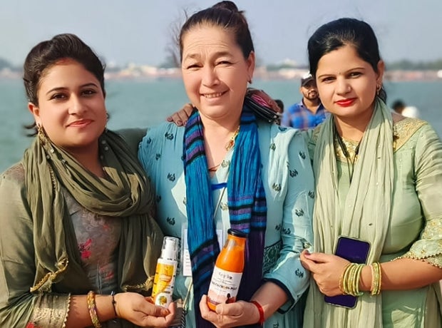 Portrait of three women holding sea buckthorn products