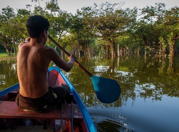 Boy on boat with paddle through Indigenous territory and protected area on the Tapajós River, Amazon - Brazil