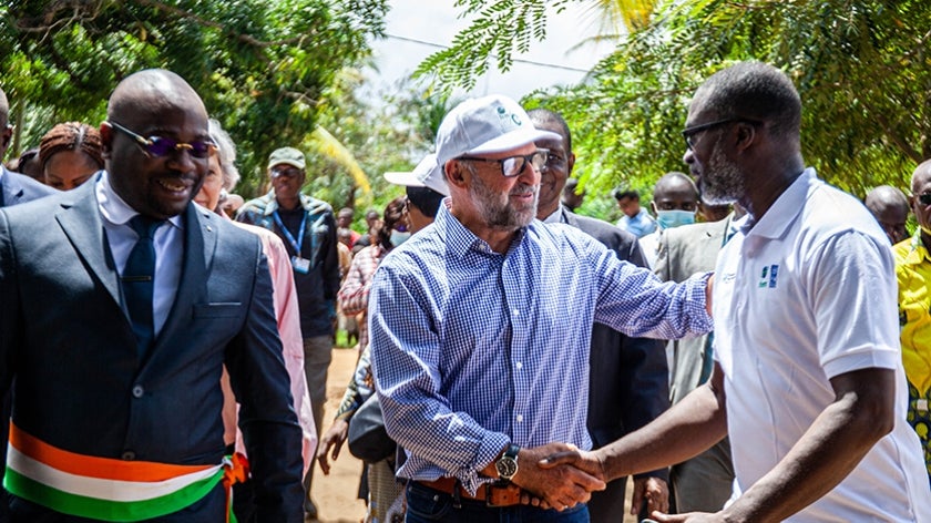 Carlos Manuel Rodriguez, CEO and Chairperson of the GEF, shaking hands with people in Marchoux village, Cote d'Ivoire