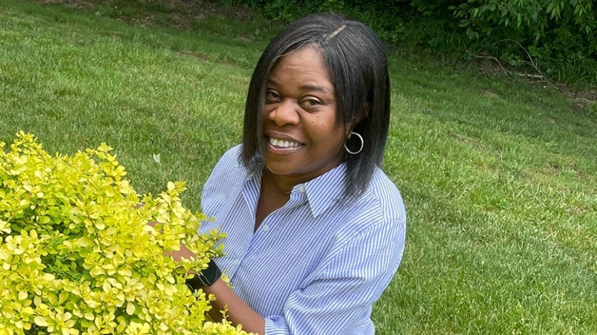 Woman crouching by a bush