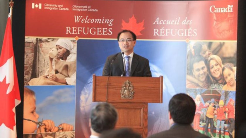 Tom Bui speaks in front of an audience at a World Refugee Day event in Canada