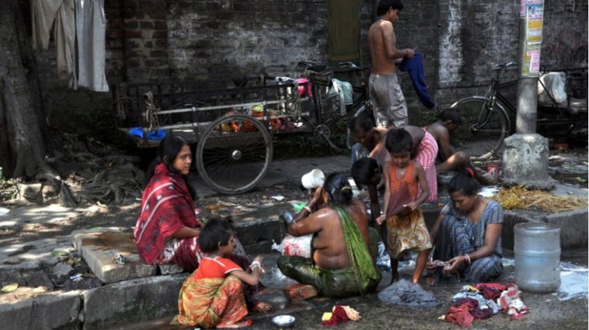 Local people wash themselves on the street of Kolkata on October 27, 2009. Homeless living on the street are common in every city of India.