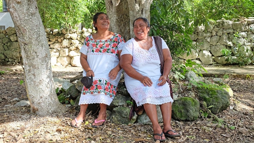 Mexican women rest against a tree