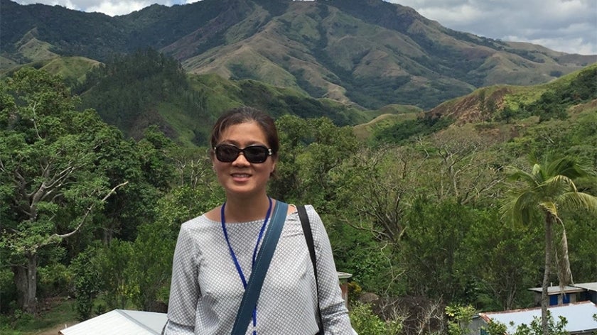 Seo-Jeong Yoon in front of a mountain and forest landscape in Navilawa village in Fiji