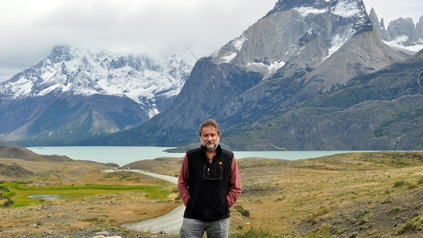 Miguel Stutzin stands in front of a mountainous landscape in Torres del Paine National Park, Chile